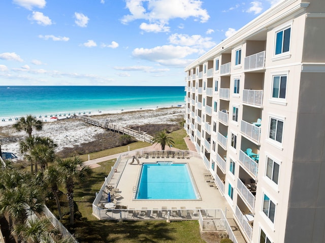 community pool with a water view and a view of the beach