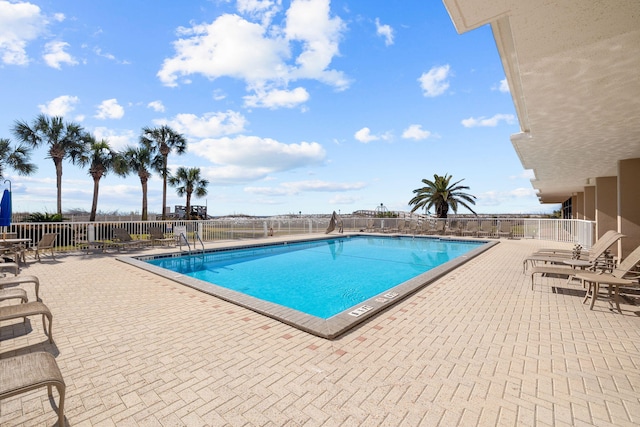 pool with fence and a patio