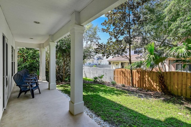 view of yard with covered porch and fence