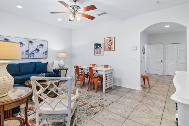 living area featuring arched walkways, light tile patterned floors, recessed lighting, visible vents, and a ceiling fan