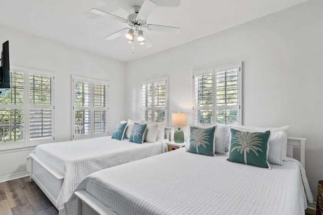 bedroom with ceiling fan, baseboards, and wood finished floors