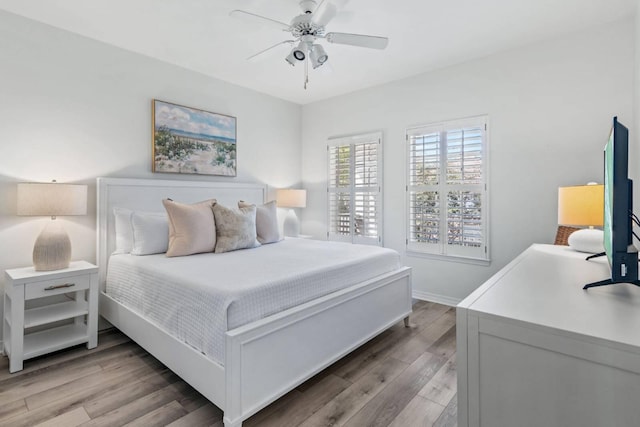 bedroom featuring light wood-type flooring, a ceiling fan, and baseboards