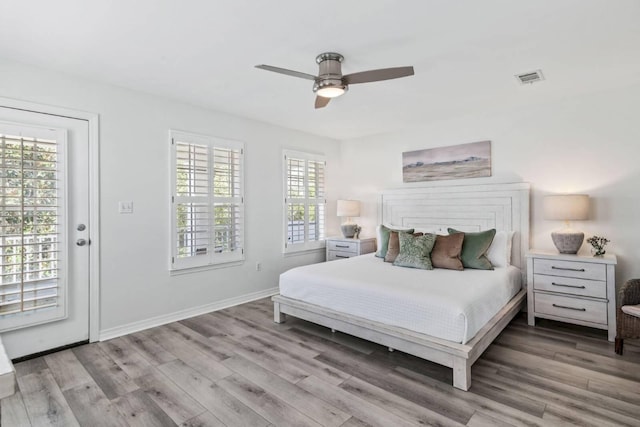 bedroom with multiple windows, light wood-type flooring, visible vents, and baseboards