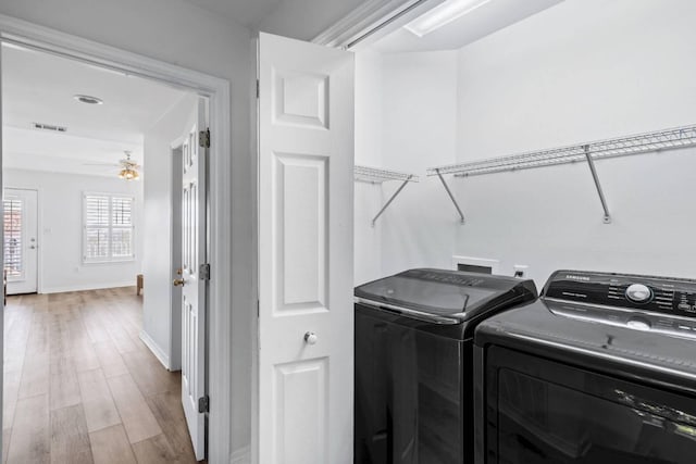 washroom with laundry area, baseboards, visible vents, washer and clothes dryer, and light wood-style floors