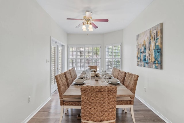 dining room featuring a ceiling fan, baseboards, and wood finished floors