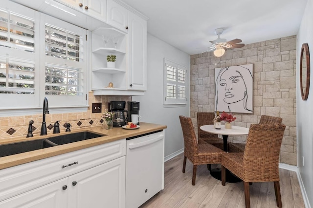 kitchen with white cabinets, dishwasher, backsplash, and a sink