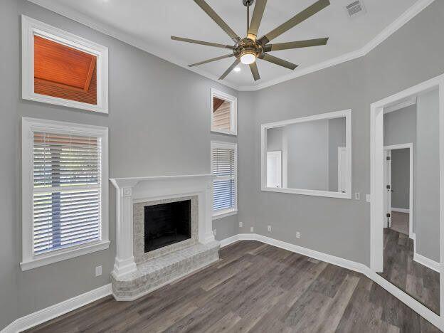 unfurnished living room featuring visible vents, a fireplace with raised hearth, and baseboards