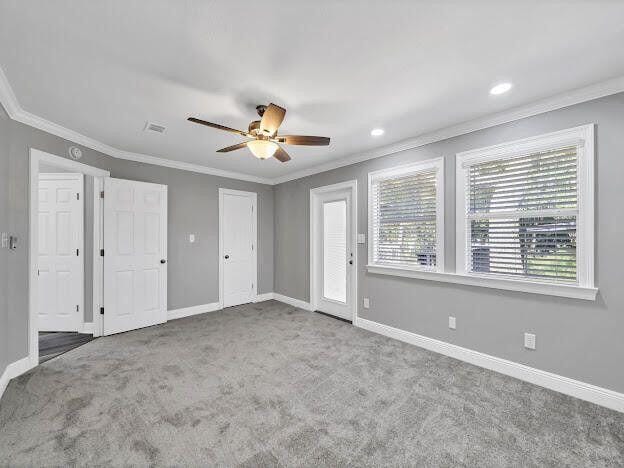 unfurnished bedroom featuring carpet floors, baseboards, and ornamental molding