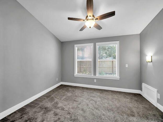 unfurnished room featuring ceiling fan, carpet, visible vents, and baseboards