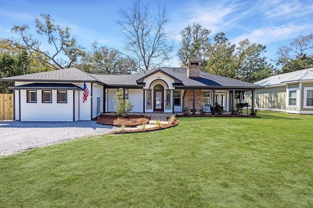 view of front of home featuring fence, driveway, roof with shingles, a chimney, and a front yard