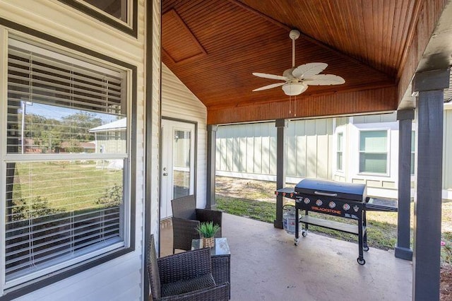 sunroom / solarium with a ceiling fan, wooden ceiling, and vaulted ceiling