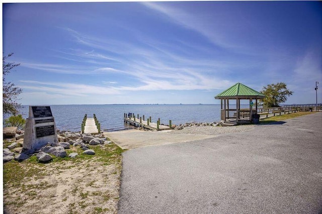 view of dock with a gazebo and a water view