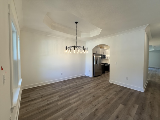 1575 Pine St, Niceville, FL 32578 - unfurnished dining area with ornamental molding, a tray ceiling, arched walkways, dark wood finished floors, and baseboards