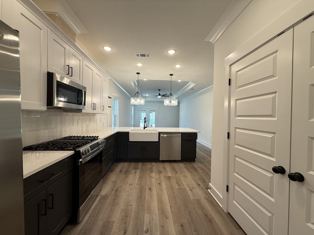 1575 Pine St, Niceville, FL 32578 - kitchen with stainless steel appliances, a sink, a peninsula, a chandelier, and recessed lighting