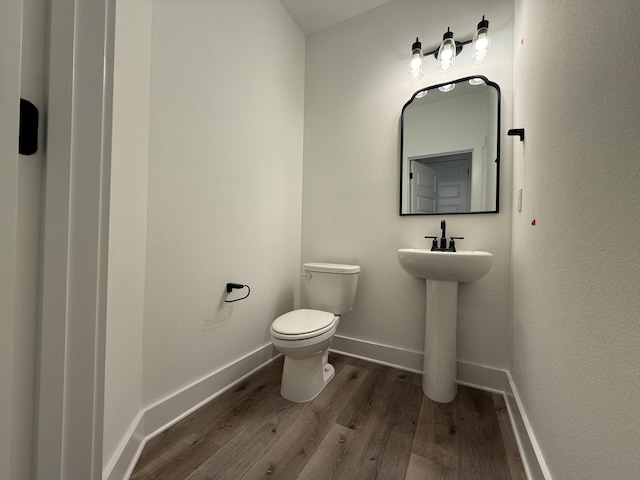 1575 Pine St, Niceville, FL 32578 - half bathroom with wood finished floors, toilet, baseboards, and a sink