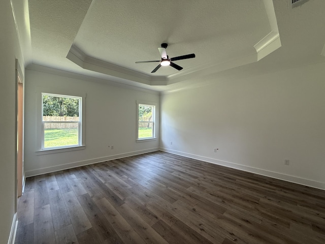 1575 Pine St, Niceville, FL 32578 - spare room featuring a tray ceiling, crown molding, a textured ceiling, dark wood finished floors, and ceiling fan