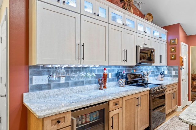 kitchen with light stone counters, wine cooler, appliances with stainless steel finishes, backsplash, and glass insert cabinets