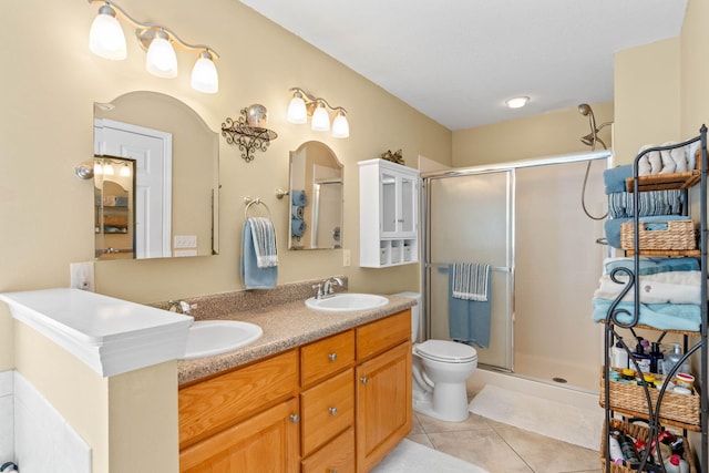 bathroom with a stall shower, tile patterned flooring, and a sink