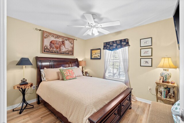 bedroom with ceiling fan, light wood-style flooring, and baseboards