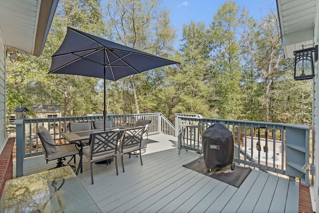 deck featuring outdoor dining area and grilling area