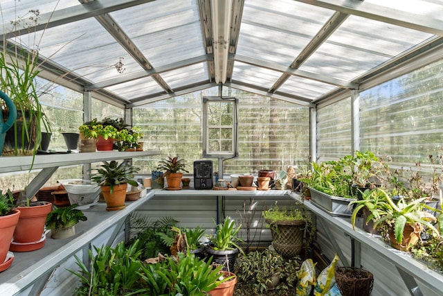 sunroom with ceiling fan and lofted ceiling with beams