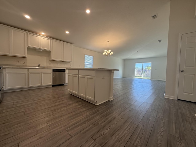 kitchen featuring stainless steel dishwasher, white cabinets, and a chandelier