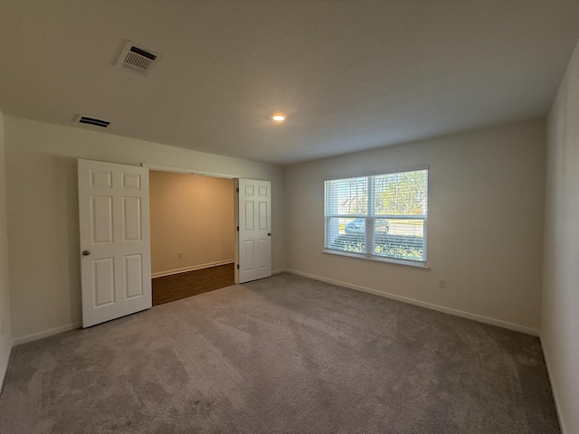 unfurnished bedroom with visible vents, carpet flooring, and baseboards