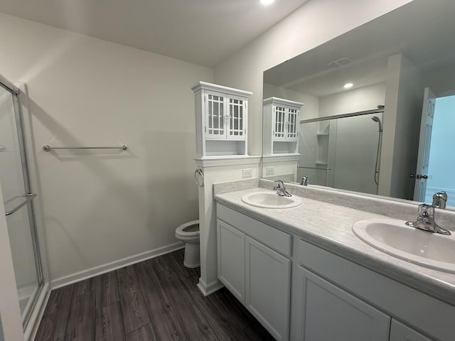 full bathroom featuring a shower stall, toilet, wood finished floors, and a sink