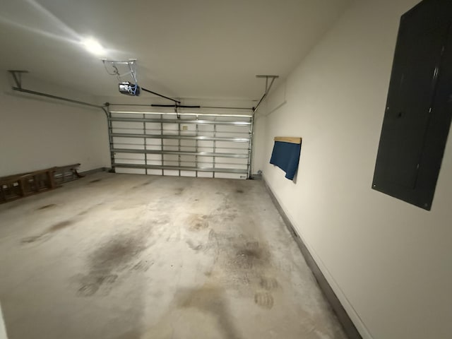 garage with electric panel, baseboards, and a garage door opener