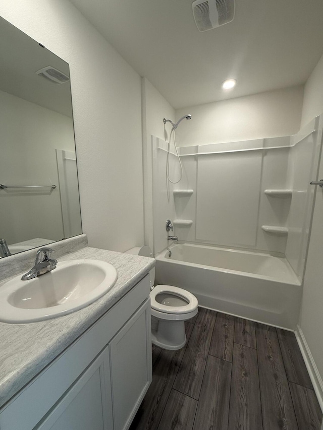 bathroom featuring vanity, washtub / shower combination, wood finished floors, visible vents, and toilet