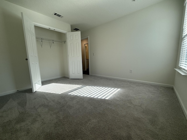 unfurnished bedroom featuring a closet, visible vents, and carpet floors