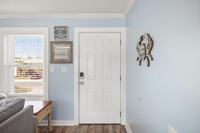 entrance foyer with baseboards, a textured ceiling, ornamental molding, and dark wood-type flooring