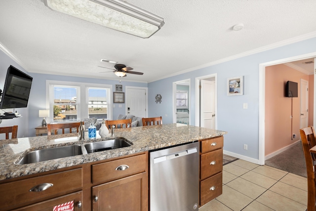 kitchen featuring light tile patterned flooring, a sink, brown cabinets, dishwasher, and crown molding