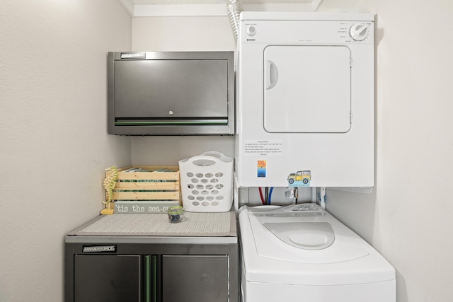 clothes washing area featuring laundry area and stacked washing maching and dryer