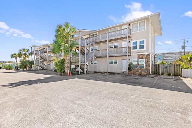 view of property with uncovered parking and fence