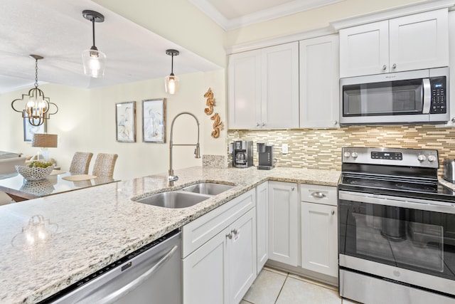 kitchen with ornamental molding, a sink, backsplash, appliances with stainless steel finishes, and white cabinets