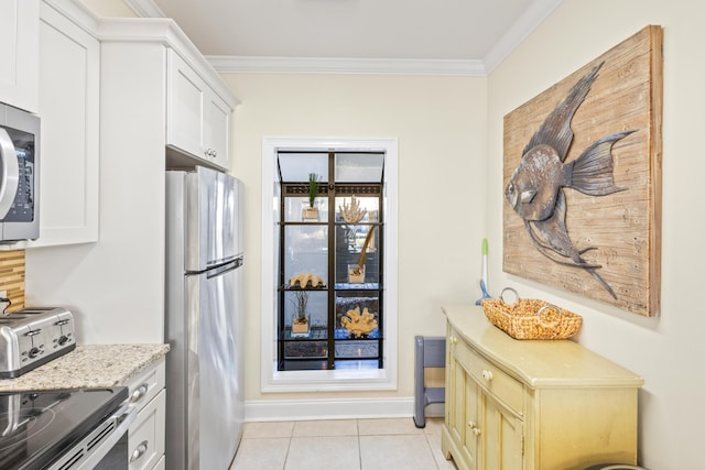 kitchen featuring crown molding, baseboards, appliances with stainless steel finishes, light tile patterned flooring, and white cabinets