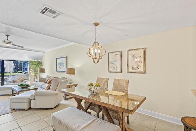 dining space featuring visible vents, baseboards, light tile patterned floors, ceiling fan with notable chandelier, and a textured ceiling