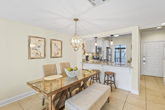 dining area with light tile patterned floors, visible vents, and baseboards