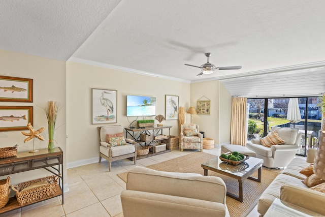 living room with ceiling fan, baseboards, ornamental molding, light tile patterned floors, and a textured ceiling