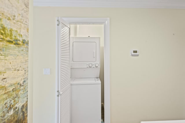 washroom with ornamental molding, laundry area, and stacked washer / dryer