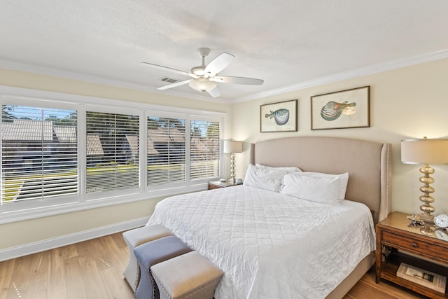 bedroom featuring baseboards, wood finished floors, a ceiling fan, and ornamental molding