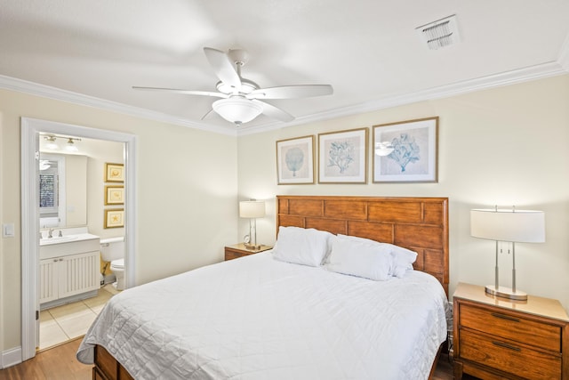 bedroom featuring ceiling fan, crown molding, visible vents, and connected bathroom