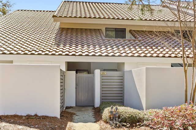 exterior space with a tiled roof, a gate, and fence