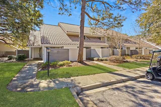 view of front of property featuring stucco siding, fence, and a tiled roof