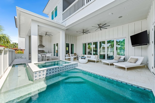 view of swimming pool featuring a patio area, a pool with connected hot tub, outdoor lounge area, and a ceiling fan