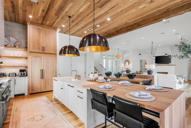 kitchen with range with two ovens, recessed lighting, wooden ceiling, and a sink