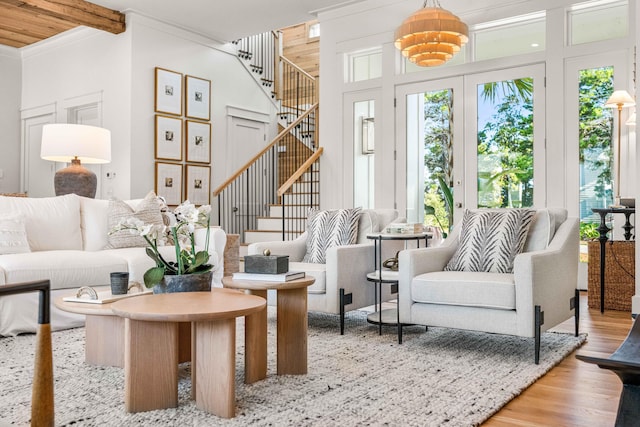 interior space with crown molding, beamed ceiling, stairway, and wood finished floors