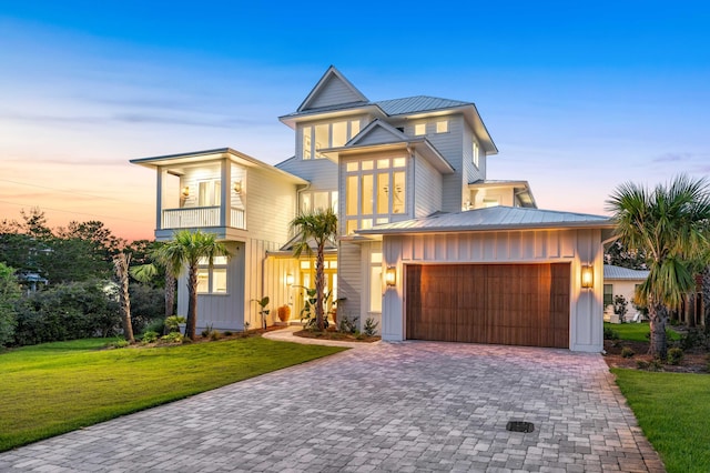 view of front of house featuring a yard, decorative driveway, board and batten siding, and a balcony