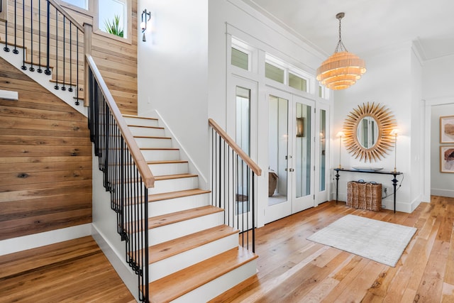 entrance foyer featuring ornamental molding, stairway, and wood-type flooring